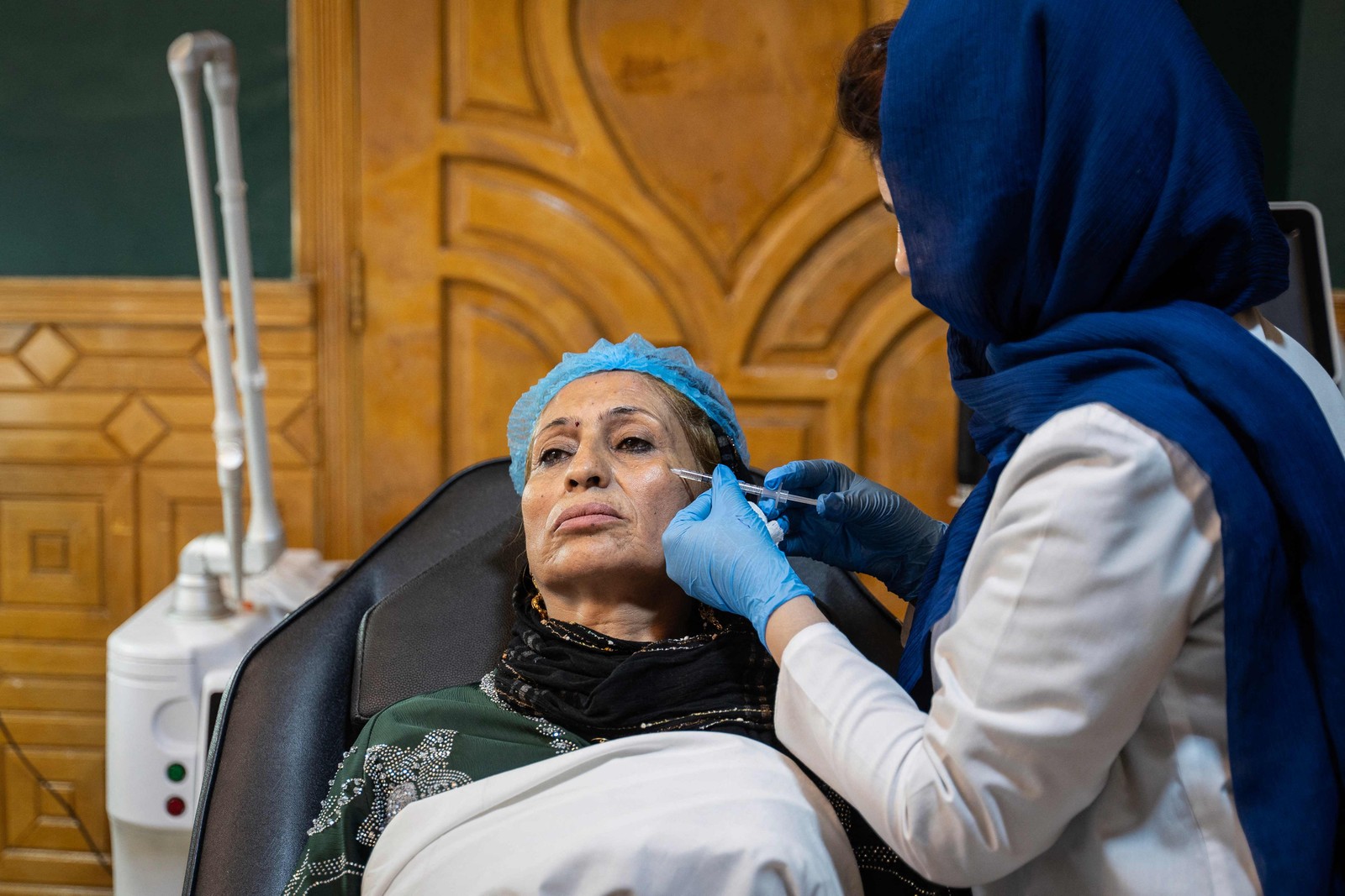 Médica injeta uma dose de Botox no rosto de uma mulher afegã em uma clínica de estética em Cabul — Foto: Wakil KOHSAR / AFP