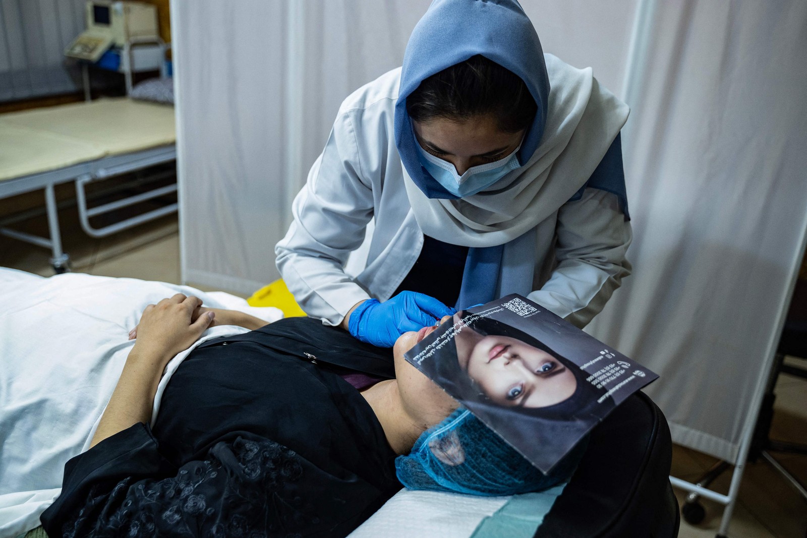 Mulher afegã faz preenchimento labial em uma clínica de estética em Cabul. — Foto: Wakil KOHSAR / AFP