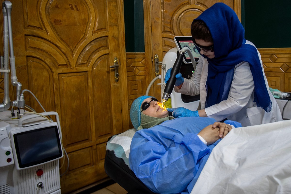 Mulher afegã recebe um tratamento a laser no rosto em uma clínica de beleza em Cabul — Foto: Foto por WAKIL KOHSAR/AFP