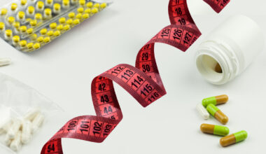 Fotomontagem na qual se vê uma fita métrica ao lado de vários medicamentos usados para emagrecimento, alguns deles ainda em cartelas e outros espalhados pela superfície