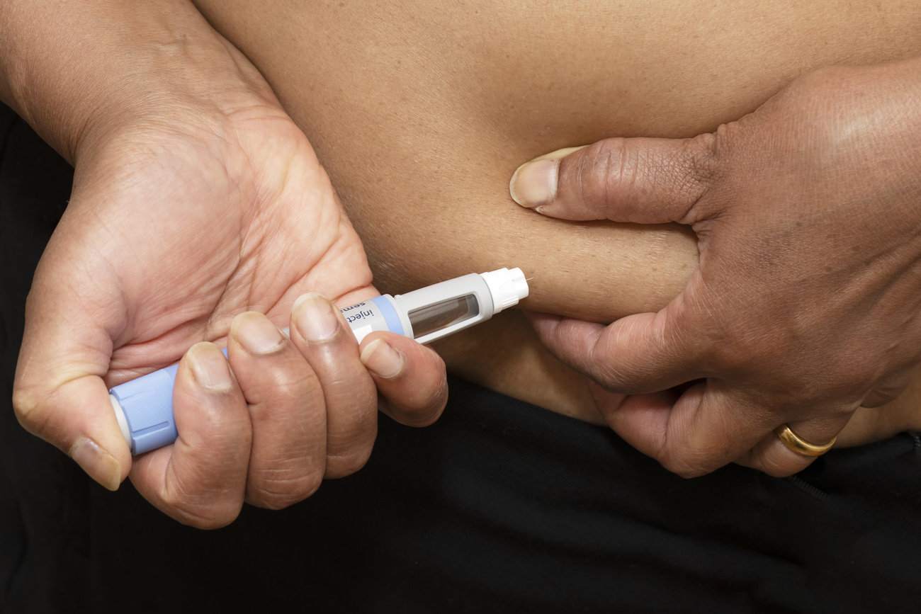 Pessoa aplicando injeção na barriga