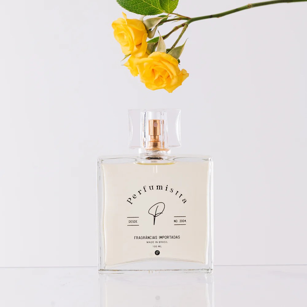 flor-de-sol-perfumista Foto de um perfume com a embalagem quadrada. Há também uma flor amarela no topo