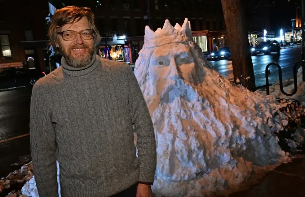 O artista bielorrusso Henrik Lojka posa ao lado de sua escultura de neve representando o rei lituano Mindaugas — Foto: Reprodução/Redes sociais