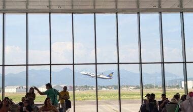 Avion Ryanair în zbor văzut din aeroport. Pasageri așteptând zborul care să-i ducă acasă.