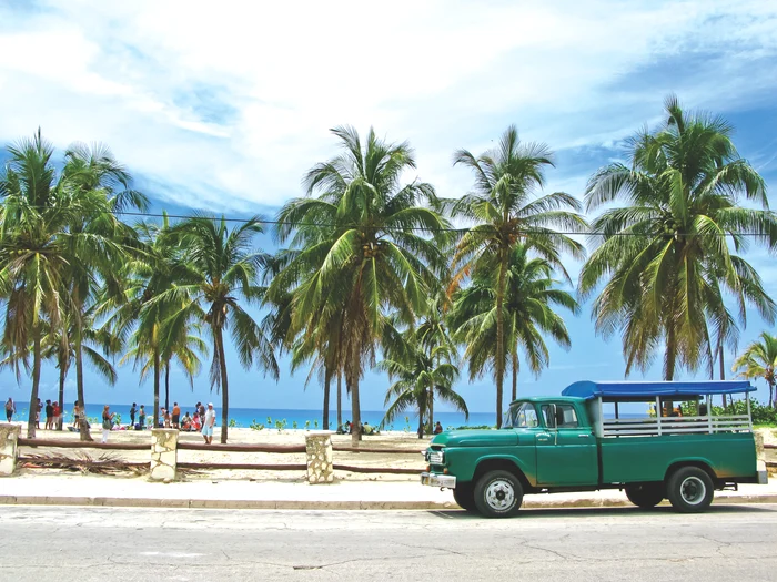 O mașină verde lângă o plajă din Cuba