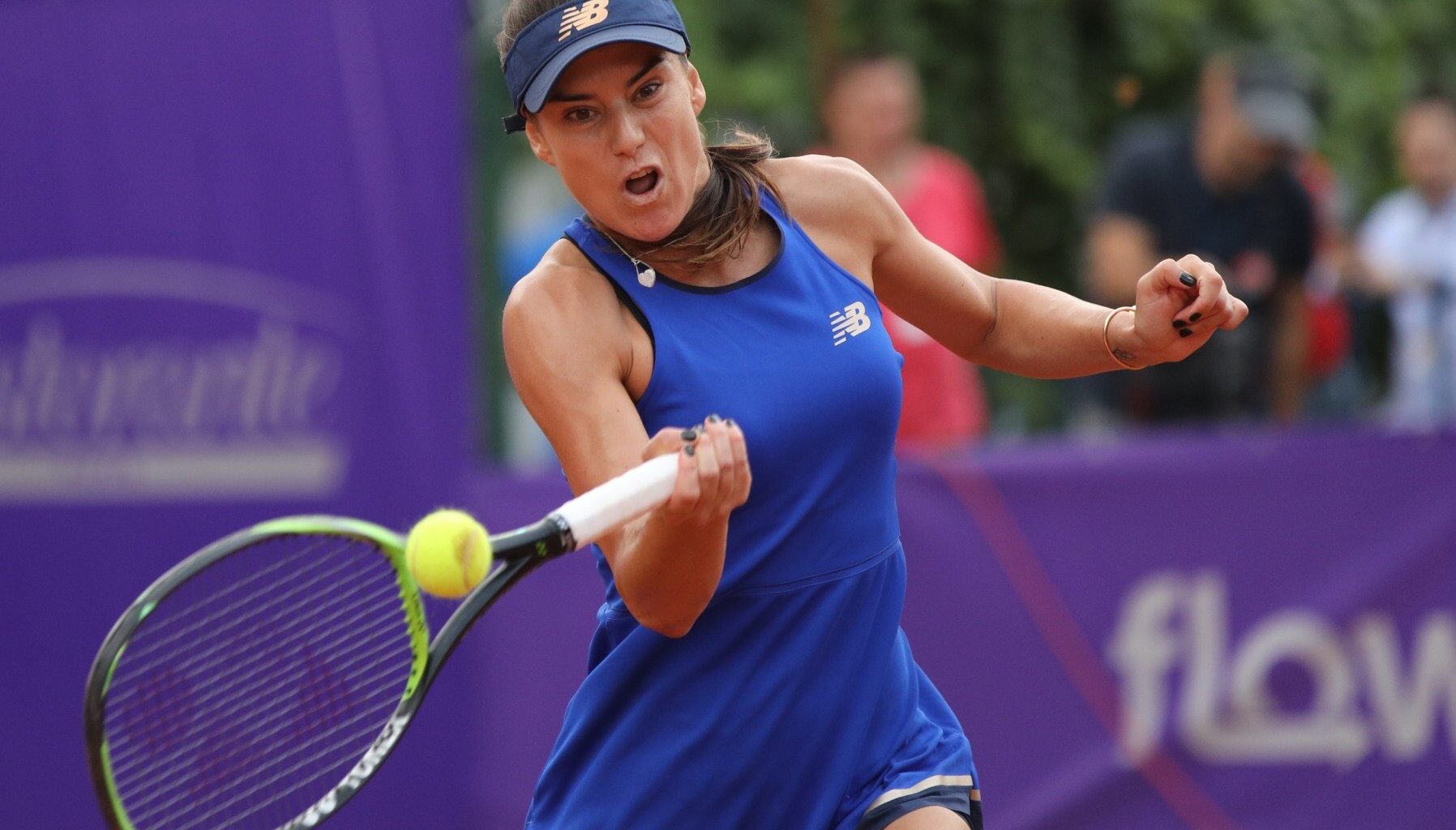 Sorana Cîrstea lovind mingea de tenis cu un forehand la un turneu din circuitul WTA.