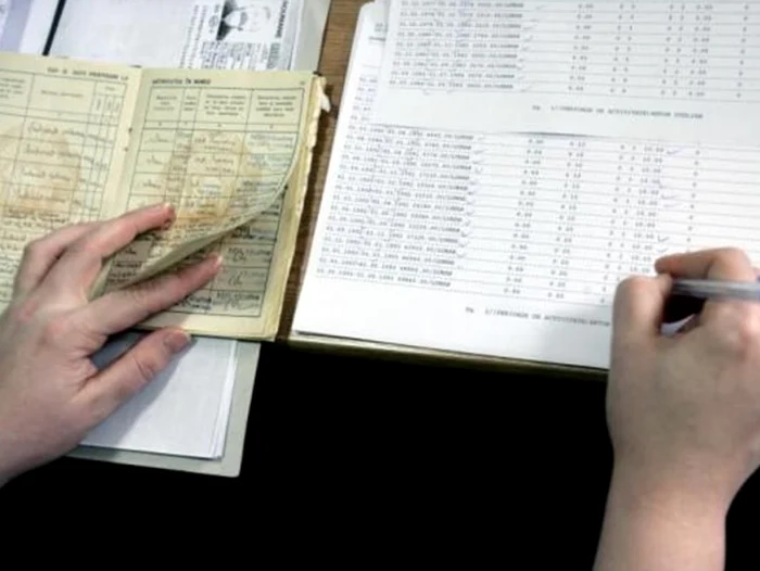 Cineva transcrie datele din cartea de muncă într-un registru