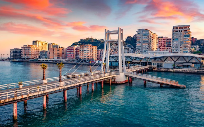 Peisaj frumos din Albania, cu un pod care trece peste o apă până la un cartier de blocuri