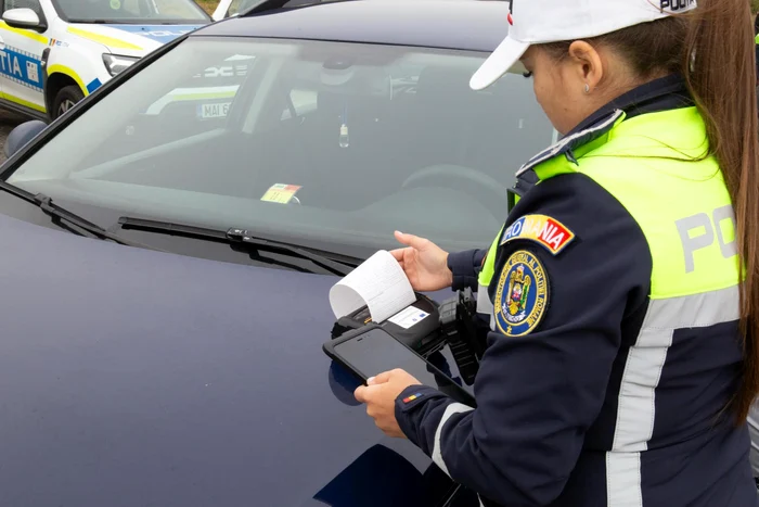 O polițistă scoate chitanța pentru amenda aplicată în trafic