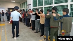 Migranți reținuți în timpul unei razii, la secția de poliție din Sankt Petersburg, 2023.