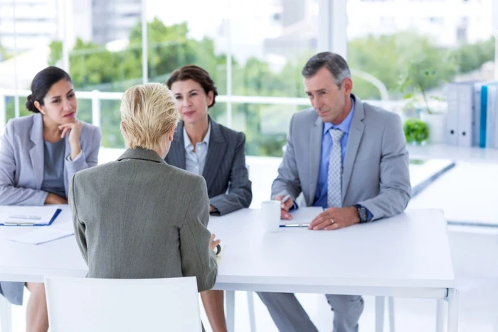 O tânără la un interviu cu trei șefi
