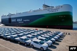Această fotografie aeriană realizată pe 15 mai 2024 arată mașini destinate exportului care așteaptă să fie încărcate pe „SAIC Anji Eternity”, o navă destinată exportului de automobile chinezești, în portul Yantai, din provincia Shandong, în estul Chinei.
