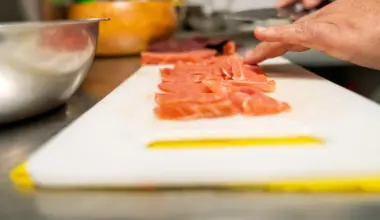 bucătar feliază somon pe un tocător