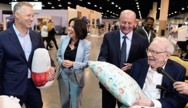 Greg Abel și Warren Buffett (dreapta) în timpul unei întâlniri de afaceri, amândoi râd și par să se simtă bine