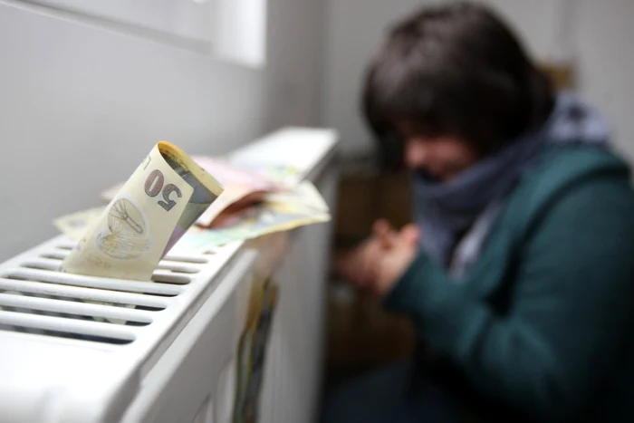 O tânără stă înfrigurată lângă caloriferul rece