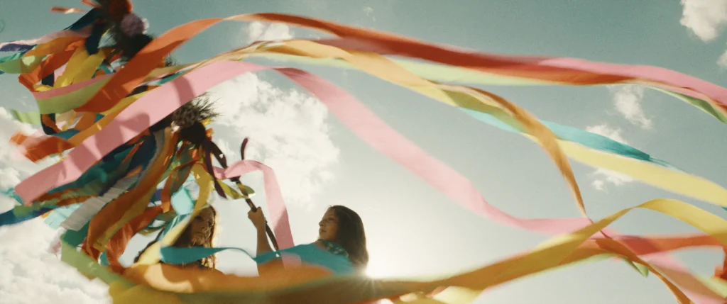 Doua fete se joaca cu multe panglici colorate