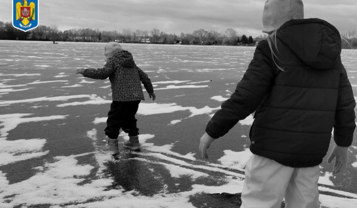 doi copii pe gheața unui lac