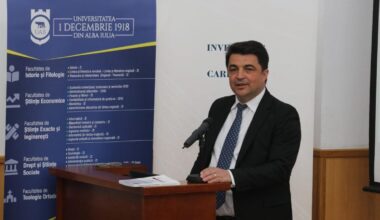 barbat in costum vorbind la pupitru