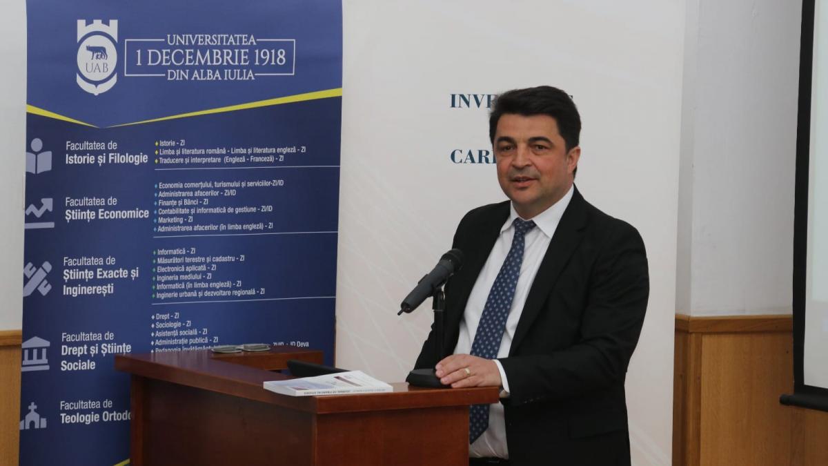 barbat in costum vorbind la pupitru