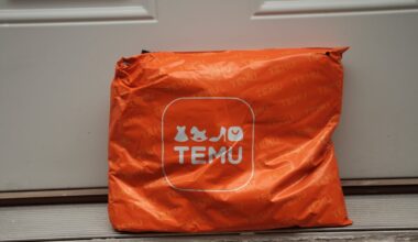 Imaginea arată un colet portocaliu inscripționat cu logo-ul Temu, lăsat în fața unei uși, sugerând o livrare.