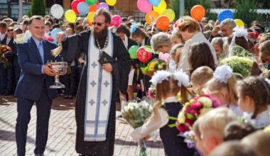 Preot ortodox care sfinteste curtea scolii la inceput de an scolar