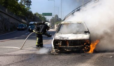 Un pompier stinge focul pornit în urma unui accident de mașină pe autostradă.