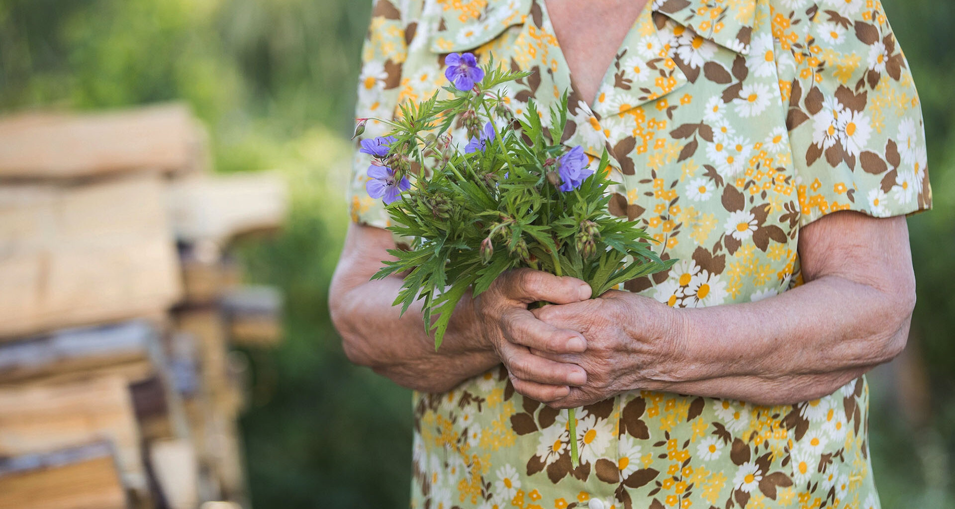 Äldre dam med en bukett blommor.