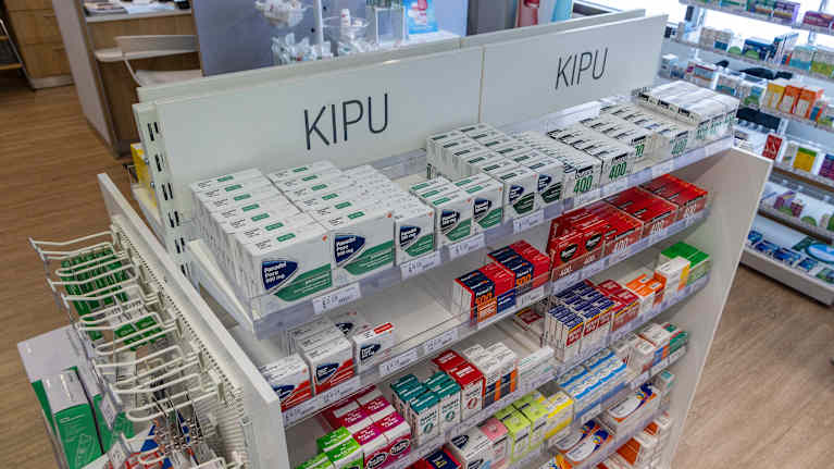 Hylla med värkmediciner i apotek.