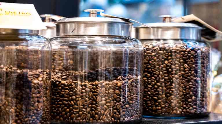 Kaffebönor i glasburkar i en kaffeaffär.