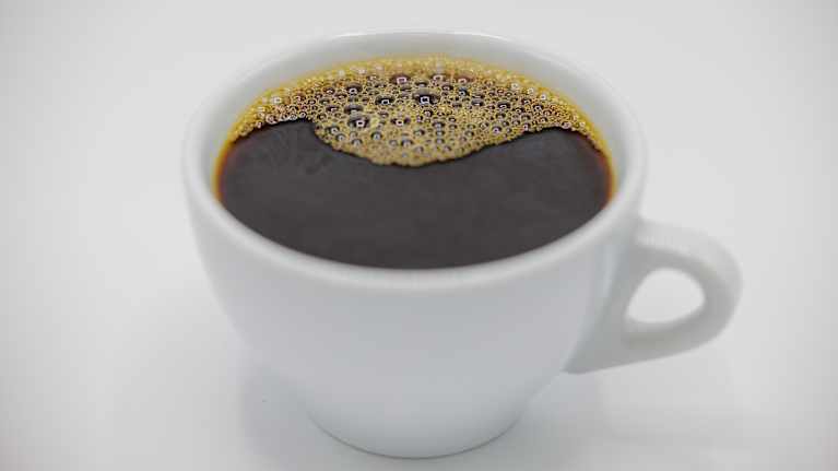 Filterkaffe i närbild upphällt i en vit kopp.