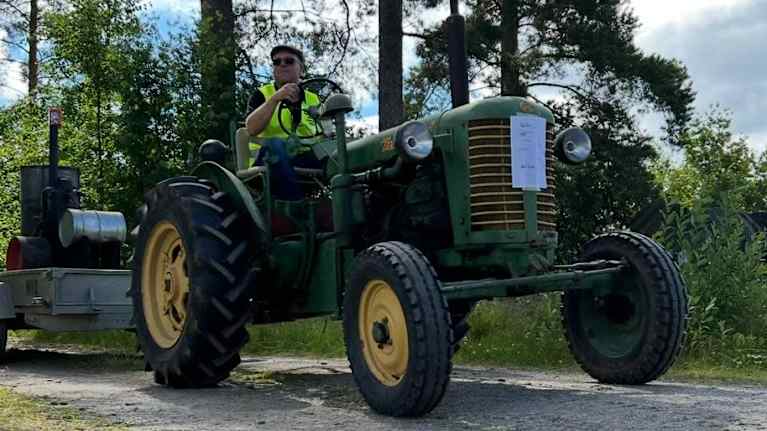 En man kör veterantraktorn Zetor 25A årsmodell 1955 med en släpkärra.