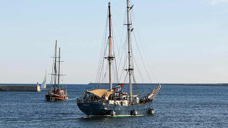 Segelbåtar ute på hav. På dem syns palestinska flaggor.