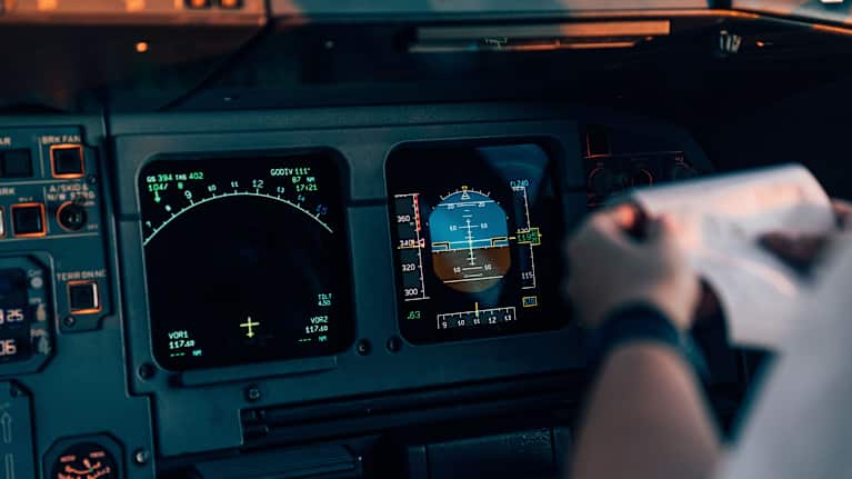 Inuti förarkabinen på ett modernt passagerarflygplan. Fokus på navigationsskärmarna.