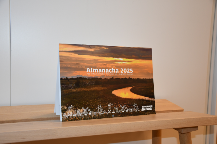 En almanacka stående på en träbänk med texten Almanacka 2025