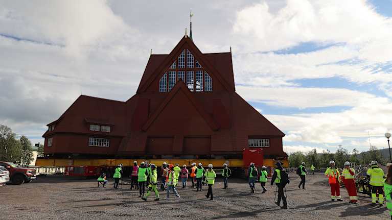 Kiruna kyrka då den skulle flyttas. Framför går arbetare i reflexväst. 