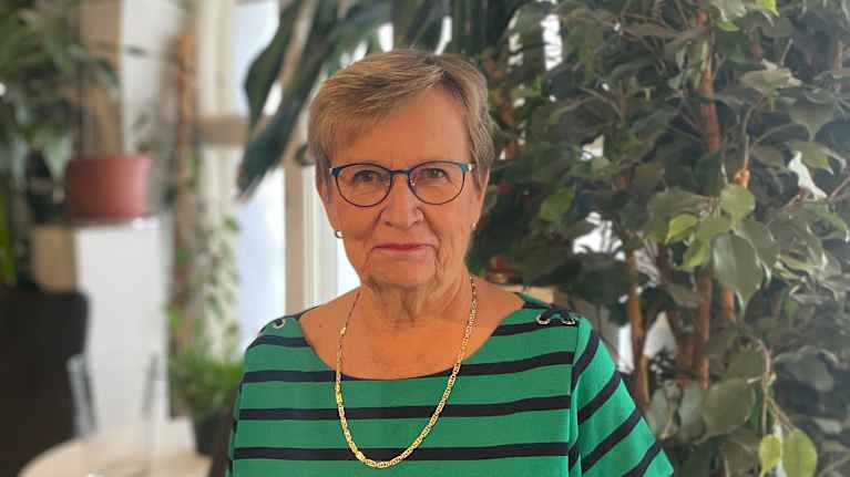 Kvinna i grönrandig klänning.