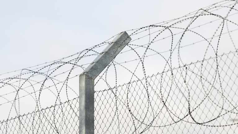 Taggtråd ovanför ett stängsel.