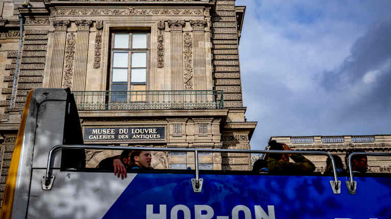 En turistbuss utanför museet Louvren i Paris. Ett fönster som söndrats vid ett inbrott.