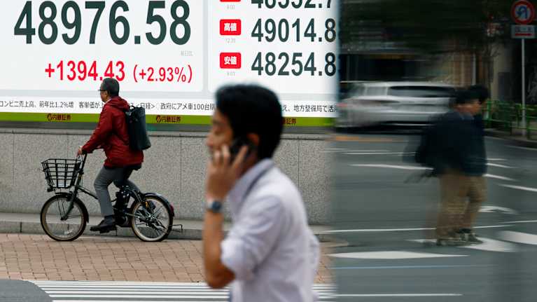 Personer går förbi siffror från den japanska marknaden i Tokyo.