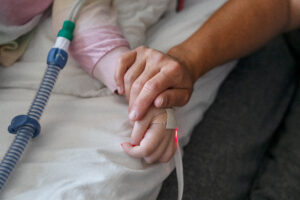 En hand håller om en mindre hand.