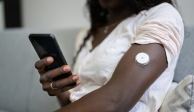 Person med knapp på armen för kontroll av blodsocker.