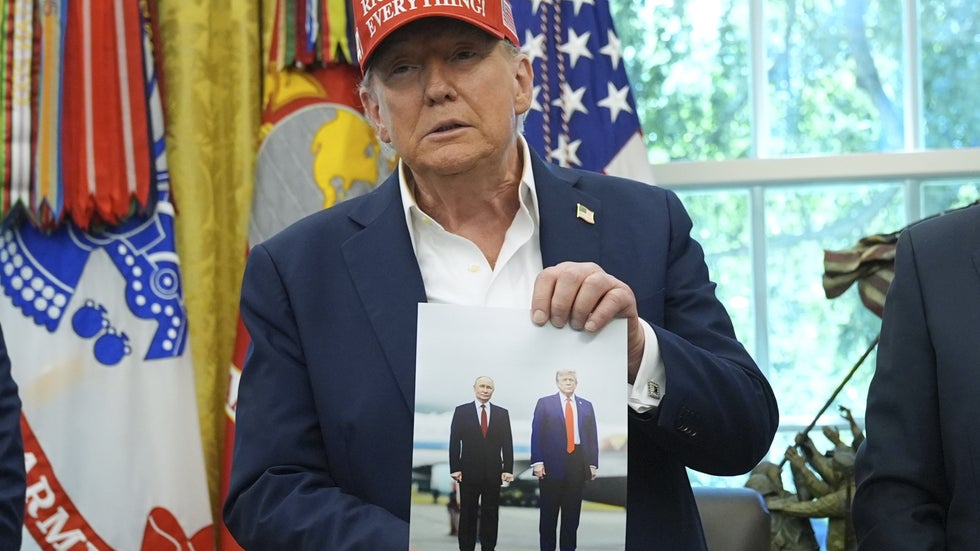 USA:s president Donald Trump håller upp ett foto av sig själv och Rysslands president Vladimir Putin, taget när de träffades i Alaska den 15 augusti. Bilden togs i Vita huset en vecka senare.