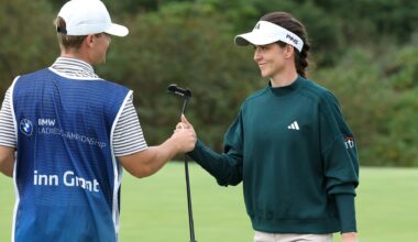 golfspelaren linn grant iklädd grön golftröja ger sin putter till caddien