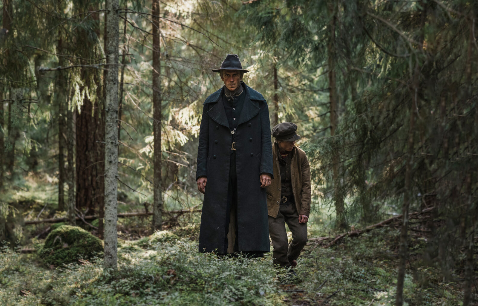 Gustaf Skarsgård och Emil Karlsen går i en skog, en scen från tv-serien Koka björn.