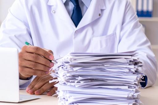 Pile of papers in front of a medical professional