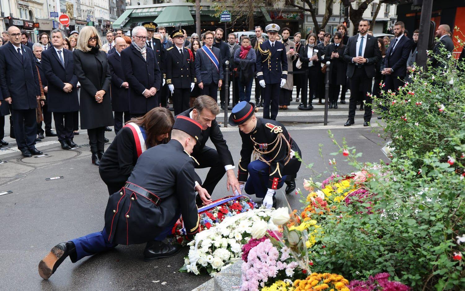 Frankrikes president lägger en minneskrans vid kafeet Le Bonne Biere café i Paris där flera personer dödades i terrordådet för tio år sedan.