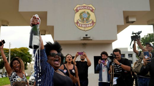 Motståndare till Jair Bolsonaros högernationalistiska rörelse fester utanför den federala polisen högkvarter där Bolsonaro sitter häktad i väntan på att föras till fängelse.