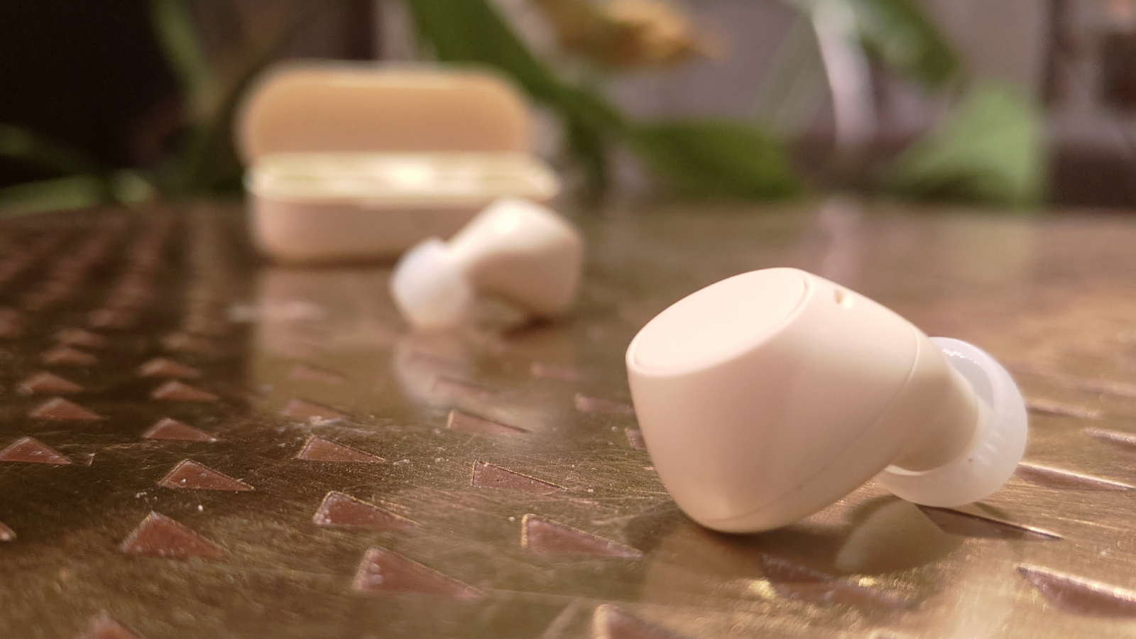 Sony WF-C510 i vitt p&aring; ett bronsf&auml;rgat bord.