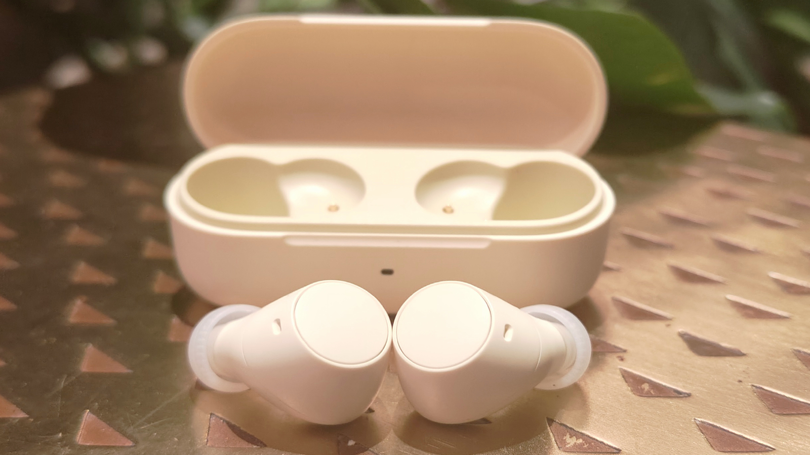 Sony WF-C510 i vitt p&aring; ett bronsf&auml;rgat bord.