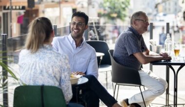 två personer sitter vid ett bord på en uteservering